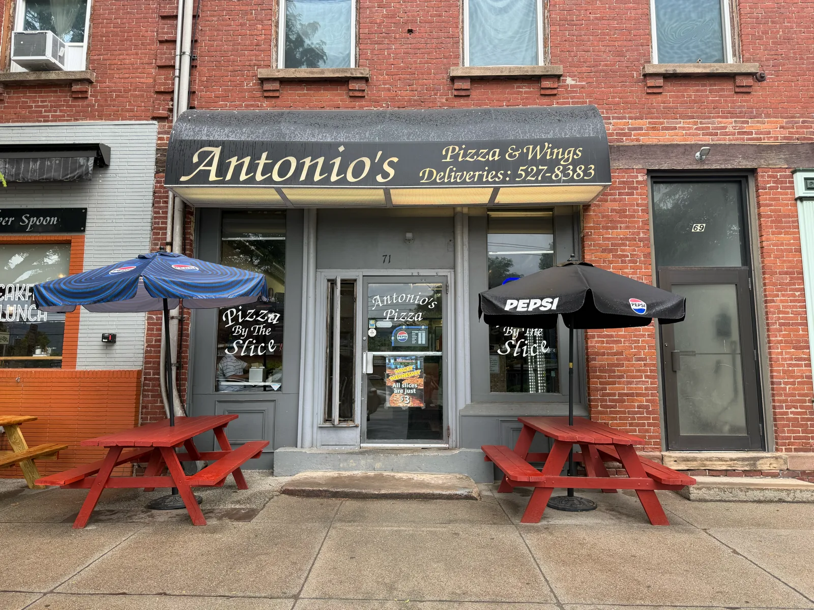 Antonio's Pizza storefront at 71 Main Street, Easthampton, with red picnic tables and umbrellas