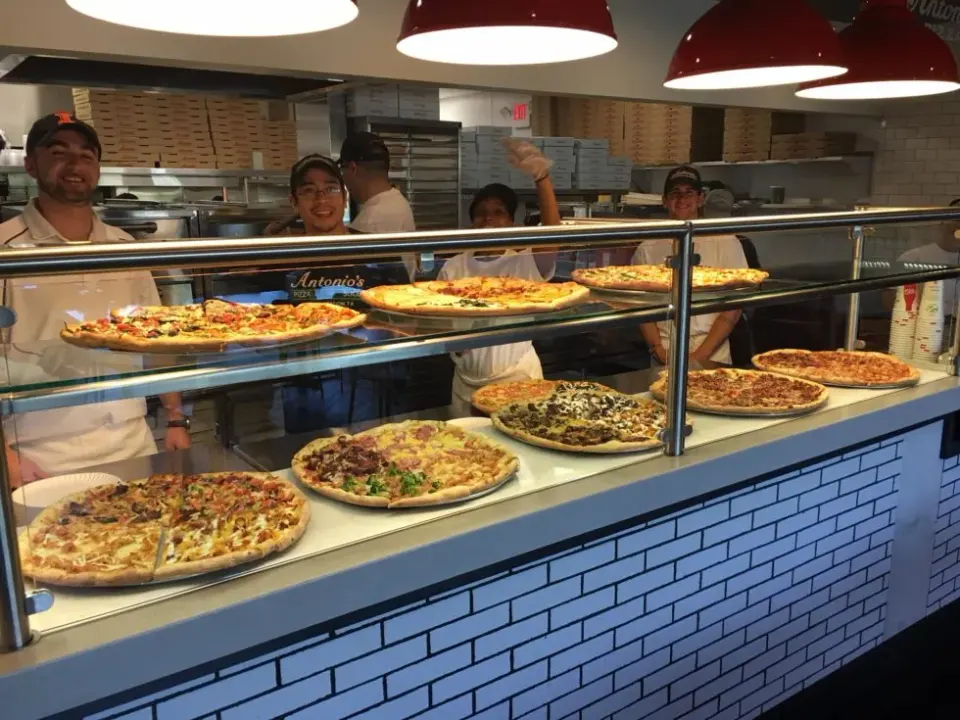 Antonio's crew behind the pizza counter on Connell Highway in Newport
