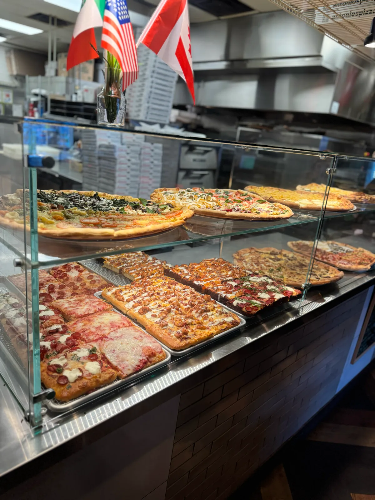 Slice case full of whole pizzas and Detroit-style squares at Antonio's Pizza Pawtucket