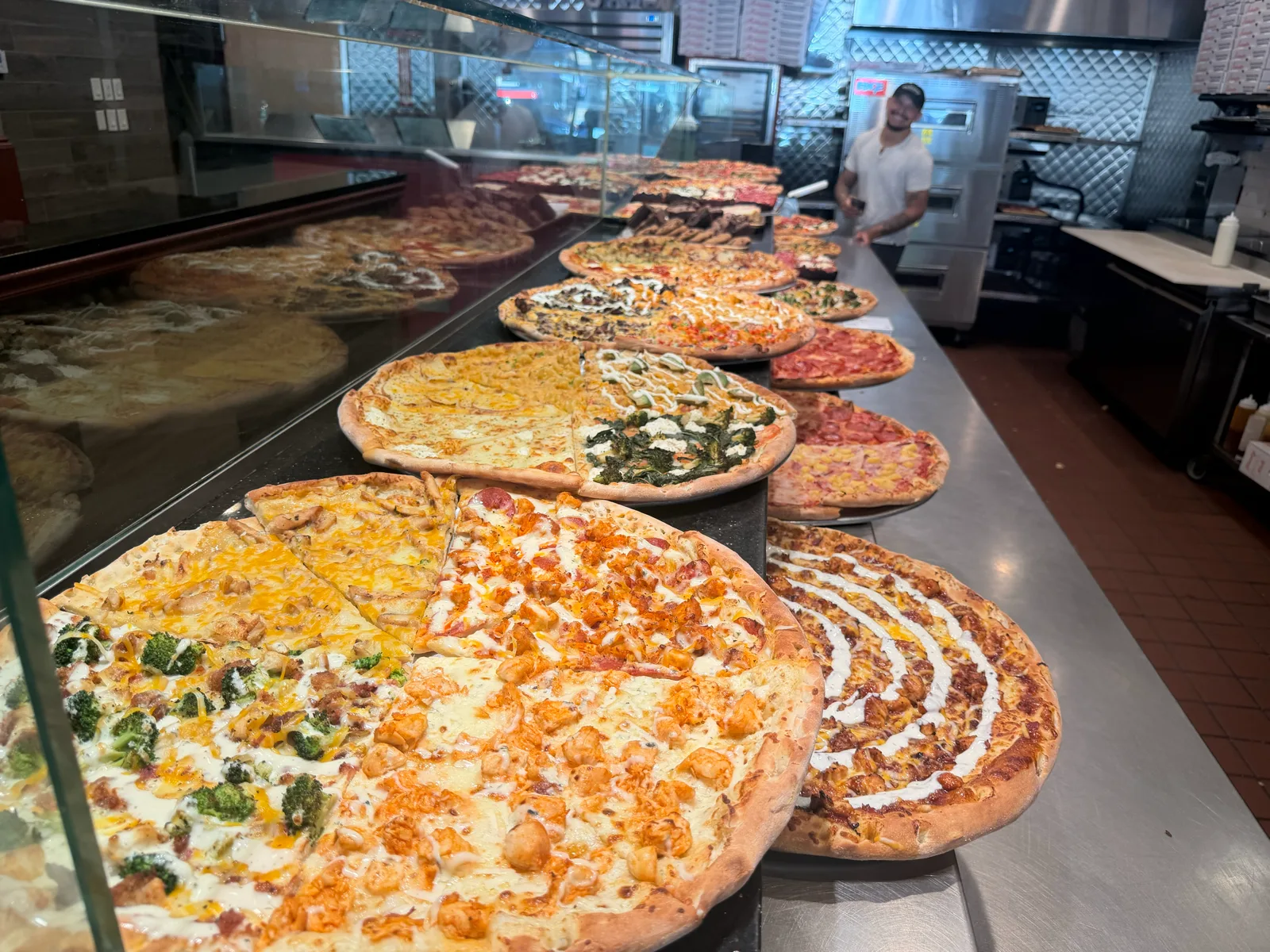 Team member behind the slice case and open kitchen at Antonio's Thayer Street