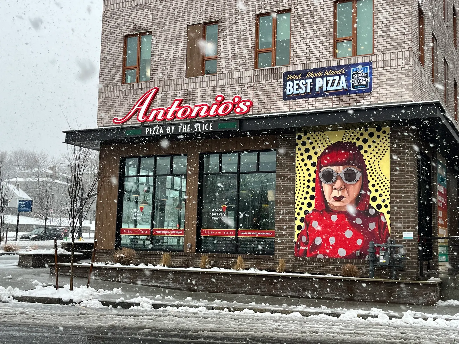 Antonio's Pizza by the Slice on Wickenden Street in Providence — corner storefront with the polka-dot mural on a snowy day