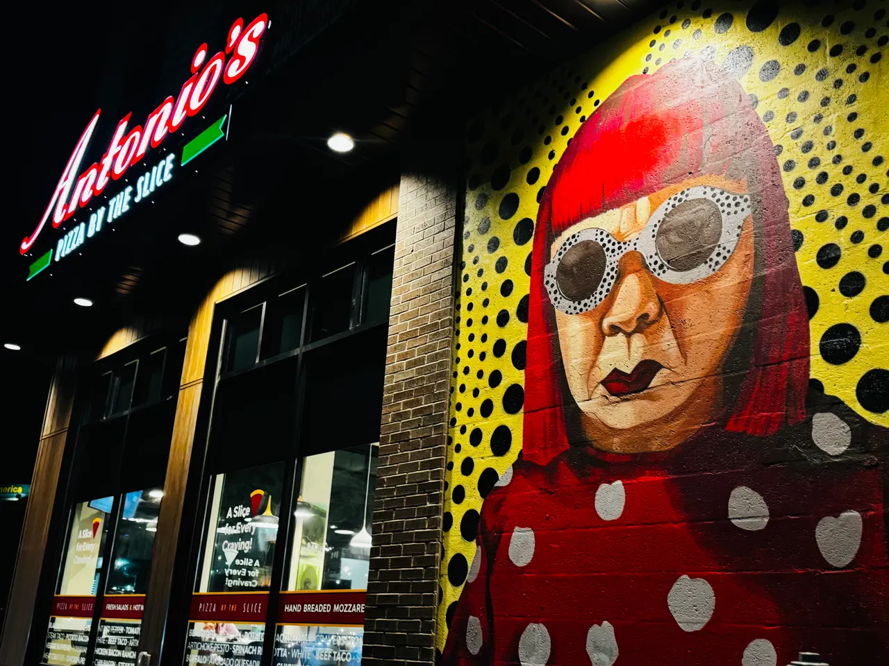 Antonio's Pizza by the Slice Wickenden Street storefront and mural lit up at night
