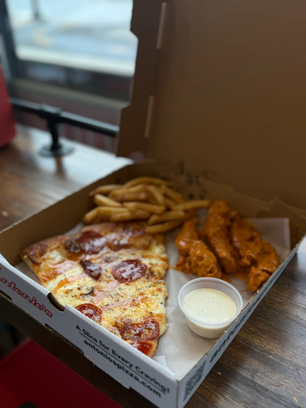 Pepperoni slice with buffalo tenders and fries in an Antonio's box at Wickenden Street