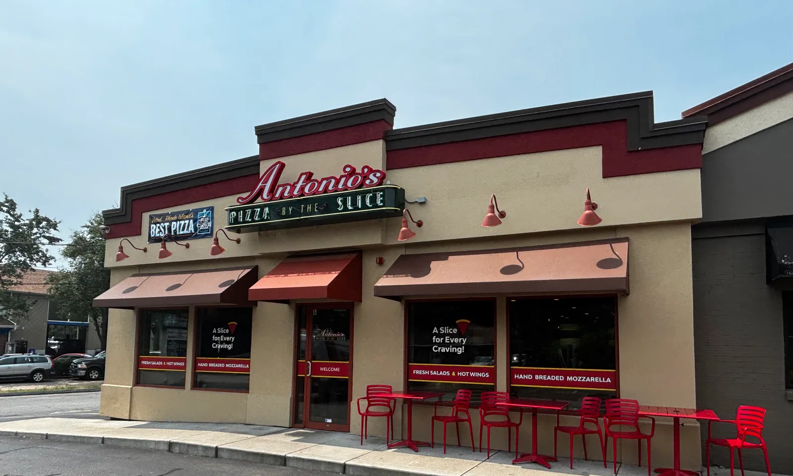 Red patio tables and chairs lined up outside Antonio's Pizza Wakefield