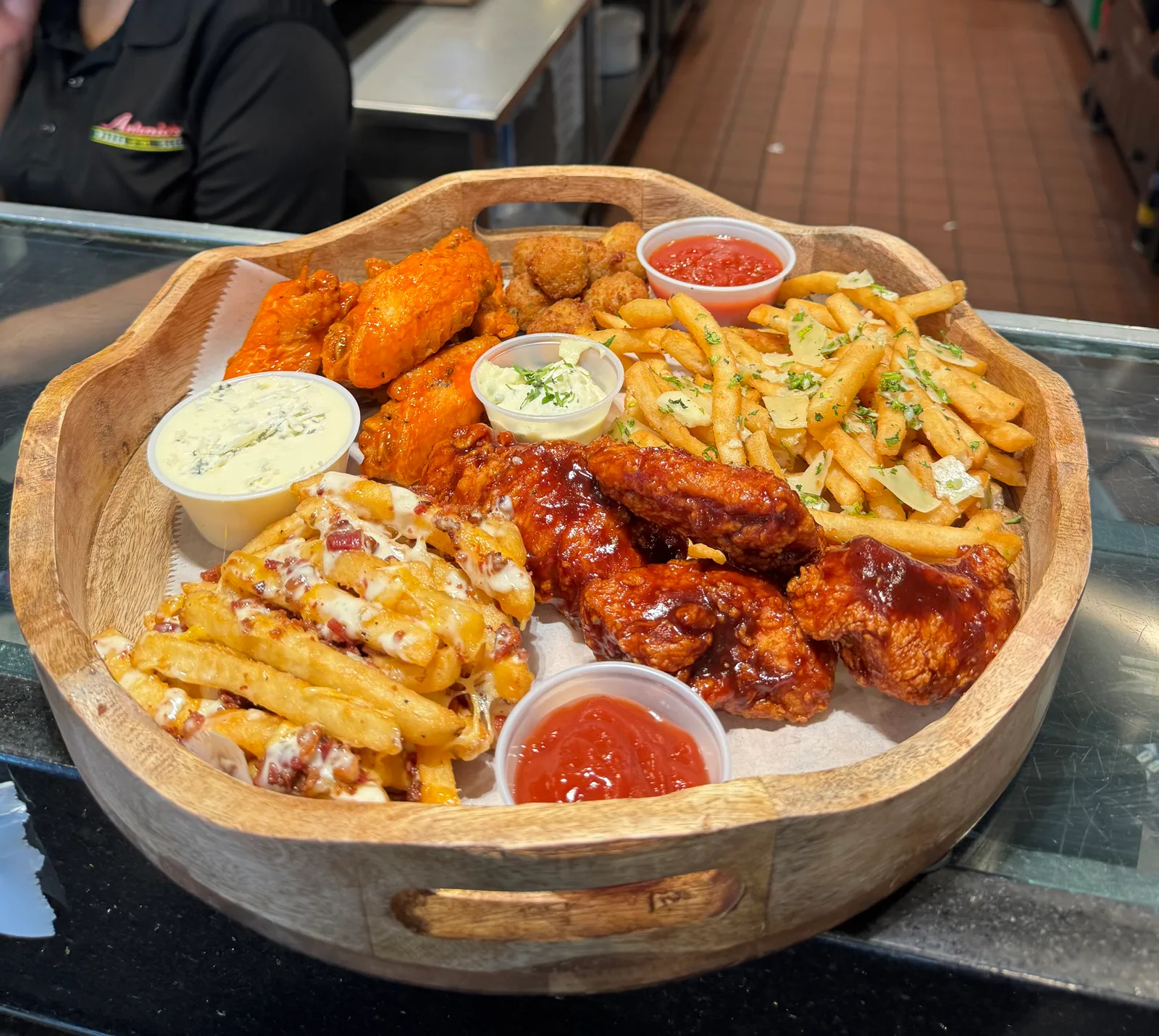 Antonio's platter of wings, tenders, loaded fries, and dipping sauces